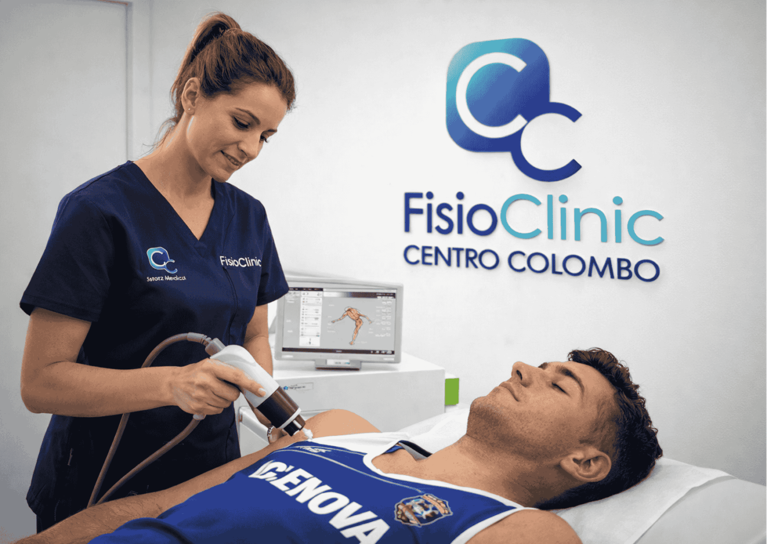Fisioterapista della FisioClinic Centro Colombo Genova mentre esegue un trattamento con onde d’urto focali Storz Medical su un paziente sportivo sdraiato supino sul lettino fisioterapico.